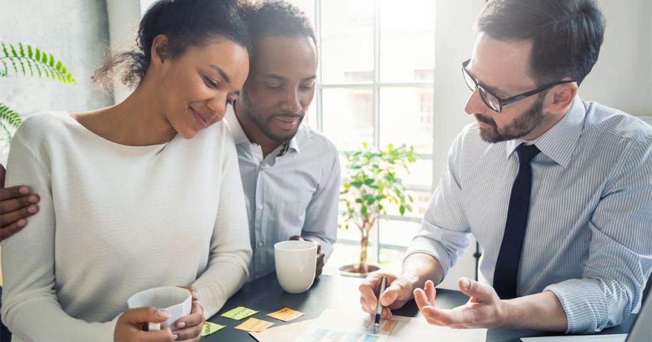 Car insurance agent helping a couple choose coverage.